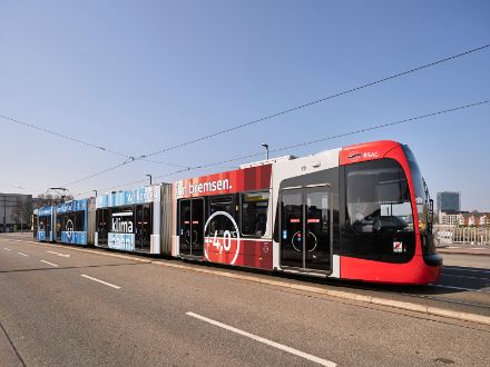 La "Klimabahn Bremen" ha ricevuto il premio Eunice Foote per la comunicazione sul clima 2022. Il tram è stampato con le "strisce del riscaldamento" e viaggerà per Brema per due anni. All'interno, vengono fornite le informazioni sul cambiamento climatico tramite la televisione, con volantini e conferenze. Immagine: © oblik.de