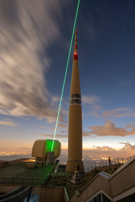 fascio laser puntato verso il cielo a fianco della torre