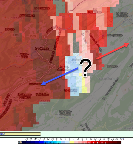 Figura 6: La componente radiale della velocita, dedotta tramite l’effetto Doppler dal radar Albis. Rosso: venti che si avvicinano al radar, cioè che soffiano verso nord-est; blu: venti che si allontanano dal radar, cioè che soffiano verso sud-ovest (freccia blu). Le due direzioni opposte indicano una rotazione su scala dell'intera cella temporalesca, ma la risoluzione non è abbastanza fine da distinguere tra un tornado e un downburst. (Fonte: Radar MétéoSuisse)