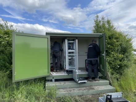 Figura 2: Due collaboratori di MeteoSvizzera smontano l'elettronica della vecchia cabina di misura.
