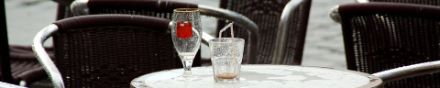 tavoli di un bar con bibite abbandonate a causa delle pioggia