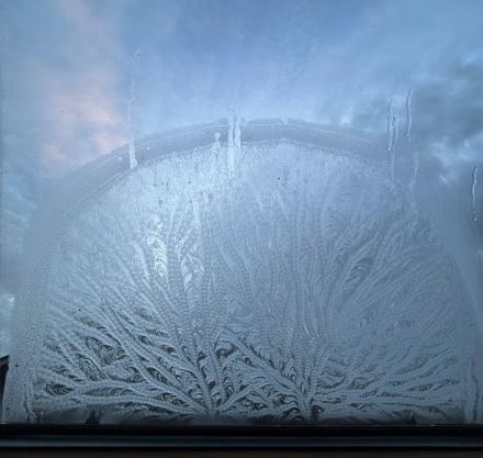 I fiori di brina creano una decorazione meravigliosa sul vetro della finestra nelle ore mattutine.