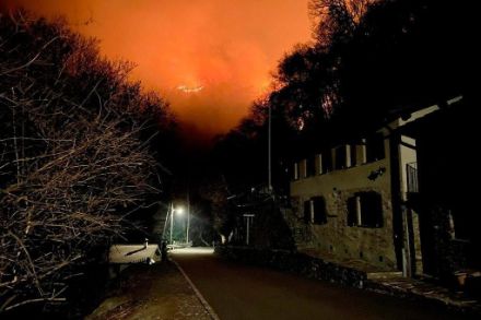 Foto scattata di notte con vista verso la valle, sullo sfondo un incendio boschivo.