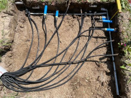 Sensori installati con cavi in una trincea di terra.