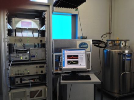 L’immagine raffigura il radiometro a microonde SOMORA a Payerne. Lo strumento quasi ottico per la detezione delle microonde si trova nell’apparecchio grigio dietro allo schermo del computer e rileva le microonde che entrano attraverso l’apposita finestra blu (trasparente per le microonde).