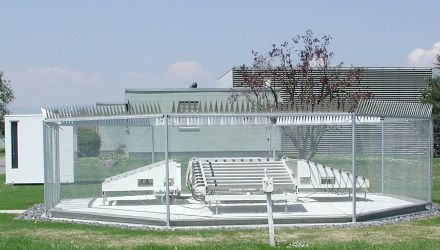 Le antenne al centro dell’immagine sotto forma di tubi bianchi disposti parallelamente, attorniate da un recinto in metallo alto due metri.