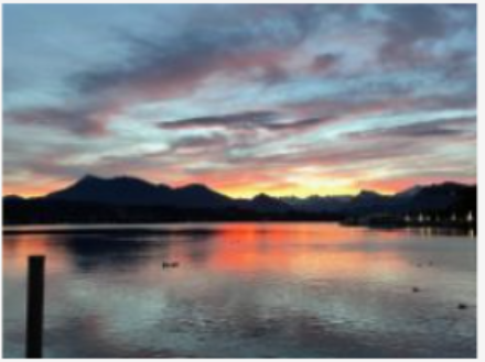 Un lago con delle montagne alle luci dell’alba.