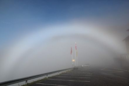 Immagine di un arco di nebbia bianco. Al di sopra dell’arco il cielo è privo di nuvole.