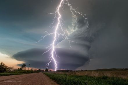  	Foto di una nuvola temporalesca che ruota su sé stessa, accompagnata da un fulmine, in una zona molto pianeggiante. 