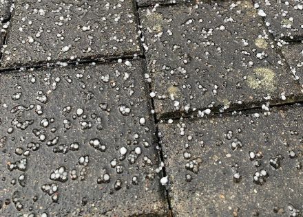 Chicchi di ghiaccio bianchi ma semitrasparenti su delle piastre di cemento.