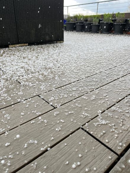 Chicchi di ghiaccio bianchi ma semitrasparenti sul pavimento di una terrazza.