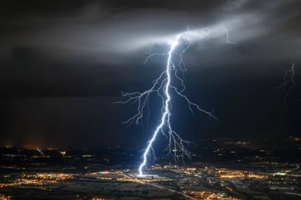 Immagine notturna di un fulmine che colpisce una città
