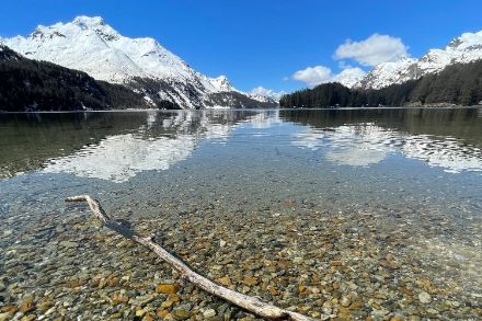 Un lago con una montagna innevata sullo sfondo.