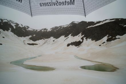 Il Lago di Carì, a 2255 metri di quota, ancora completamente ricoperto dalla neve. Questa mattina con una leggera pioggia, l’ombrello di MeteoSvizzera aiuta.  Immagine: Luca Silvanti