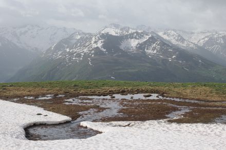 Pascolo di alta montagna con neve in fusione.