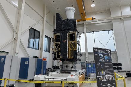 Il satellite Meteosat Third Generation Sounder (MTG-S) si trova in una camera bianca durante la fase di integrazione o di test. Si trova su una piattaforma di trasporto, circondato da barriere di sicurezza e materiale informativo.